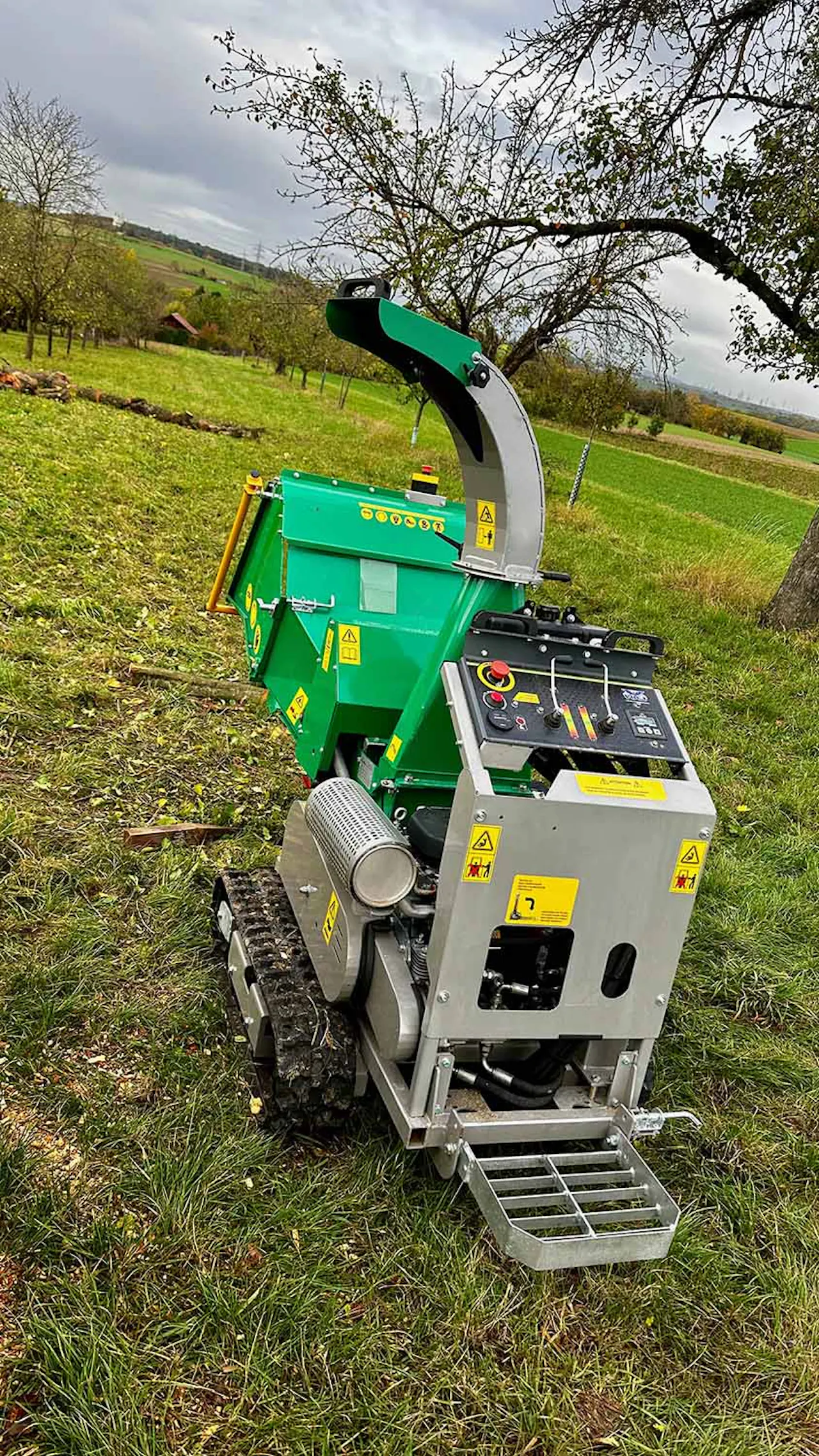 Holzhäcksler auf Raupenfahrwerk bei Häckselarbeiten auf einer Wiese